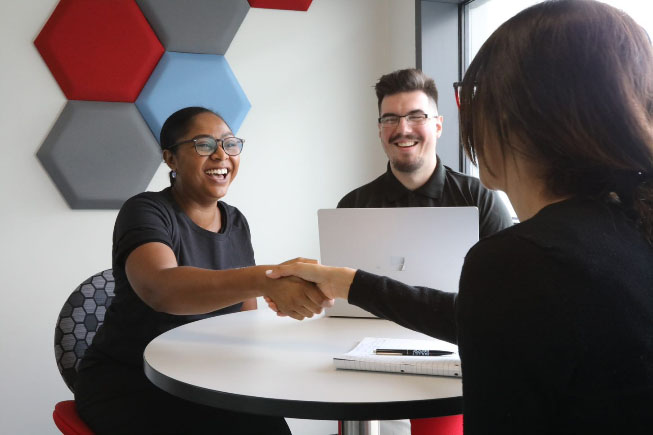 Employee shaking hands with happy client Employee shaking hands with happy client